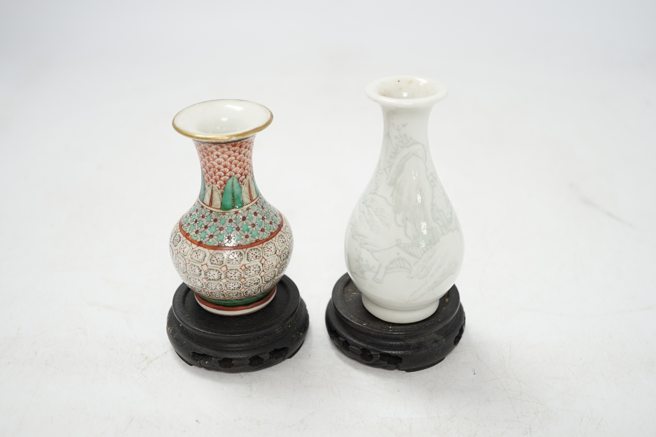 Two miniature Chinese porcelain vases, on hardwood stands, largest 9cm high. Condition - fair